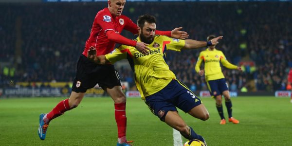 CARDIFF, WALES - DECEMBER 28:  Craig Noone (L) of Cardiff City challenges Andrea Dossena (R) of Sunderland during the Barclays Premier League match between Cardiff City and Sunderland at the Cardiff City Stadium on December 28, 2013 in Cardiff, Wales.  (Photo by Michael Steele/Getty Images)