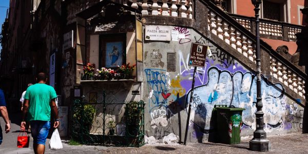 HISTORIC CITY CENTRE, NAPLES, CAMPANIA, ITALY - 2017/08/10: Men walking by a religious shrine in Piazza Bellini in the old city of Naples. (Photo by Raquel Maria Carbonell Pagola/LightRocket via Getty Images)
