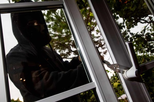 28 August 2020, Baden-Wuerttemberg, Freiburg: ILLUSTRATION - A man mimes a burglar and uses a crowbar to pry open a tilted patio door. Due to temporary curfews, the loss of cultural activities and home office, more people were at home, making it more difficult for burglars to get in. Photo: Philipp von Ditfurth/dpa (Photo by Philipp von Ditfurth/picture alliance via Getty Images)