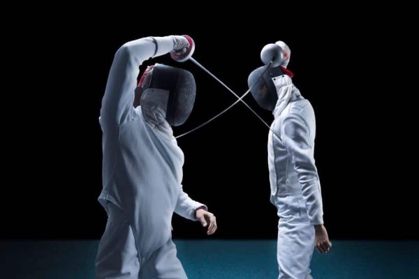Two fencers are fighting in a tournament. The concept of fencing. Mixed media